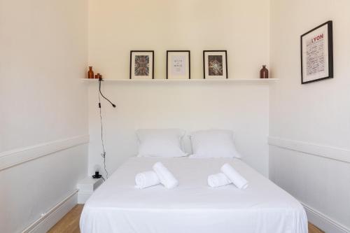 une chambre blanche avec un lit blanc avec deux oreillers dans l'établissement DIFY Enjoy - Part Dieu, à Lyon