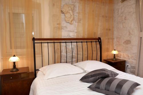 a bedroom with a bed with two lamps on tables at Villa Carrara in Trogir