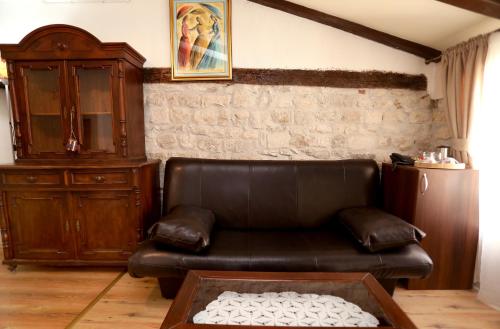 a living room with a leather couch and a cabinet at Villa Carrara in Trogir