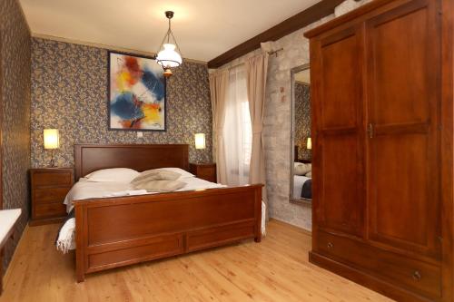 a bedroom with a wooden bed and a mirror at Villa Carrara in Trogir