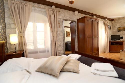 a bedroom with a white bed and a large window at Villa Carrara in Trogir