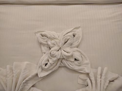 a white towel with a flower on a wall at THE DOWNTOWN in Kānpur