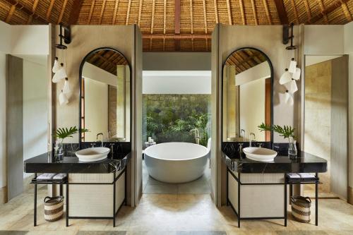 La salle de bains est pourvue de 2 lavabos et d'une baignoire. dans l'établissement Kimpton Naranta Bali, an IHG Hotel, à Nusa Dua