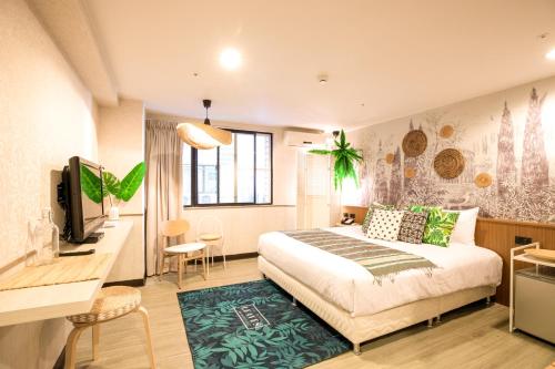 a bedroom with a bed and a desk and a tv at New Generation of Boutique Business Hotel in Kaohsiung