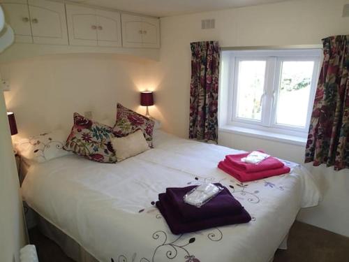 a bedroom with a bed with two towels on it at Rose Lodge in Aller