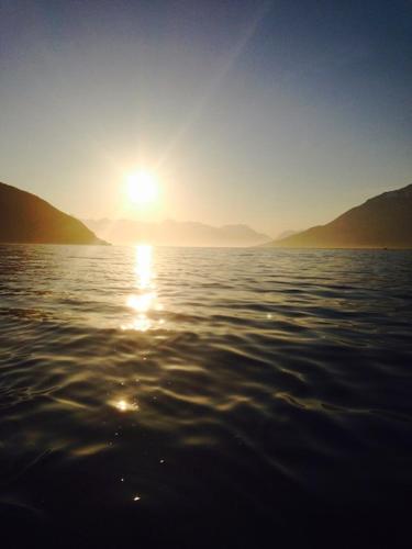 a sun setting over a body of water at Løkvollstranda camping As in Samuelsberg