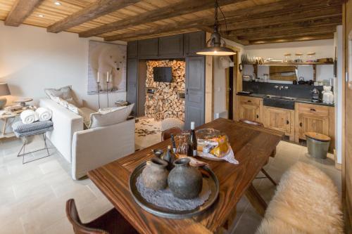 eine Küche und ein Wohnzimmer mit einem Holztisch in der Unterkunft L'Ours Blanc Lodge in Le Biot