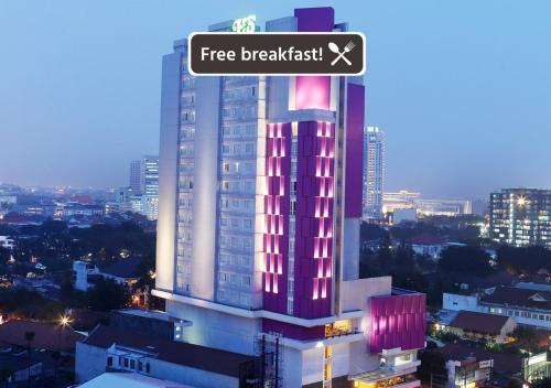 a tall building with a sign that reads free breakfast at Hotel Santika Premiere Gubeng Surabaya in Surabaya