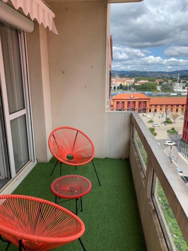 - deux tables et chaises rouges sur un balcon dans l'établissement Le Châteaucreux - Cosy & SPA, à Saint-Étienne