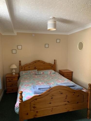 a bedroom with a wooden bed and two night stands at Kirks Cottage in Cloghan