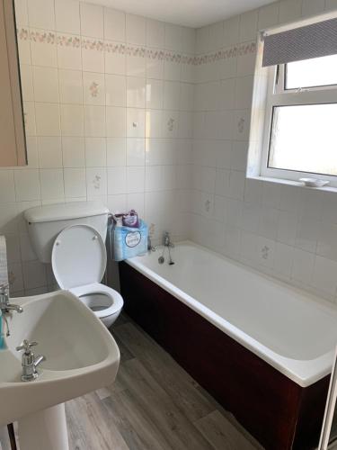 a bathroom with a tub and a toilet and a sink at Kirks Cottage in Cloghan