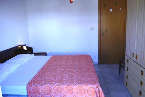 リド・デッレ・ナツィオーニにあるAppartamenti Tropiciのベッドルーム1室(ピンクの毛布付きの大型ベッド1台付)