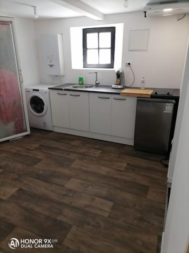 une cuisine avec un évier et une machine à laver dans l'établissement Studio aménagé en sous sol, à Arcachon