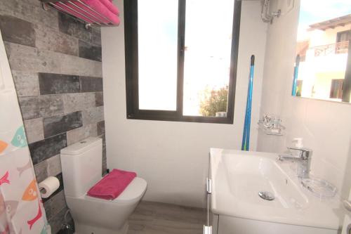 a bathroom with a toilet and a sink and a window at Jazmin, Los Dises in Puerto del Carmen