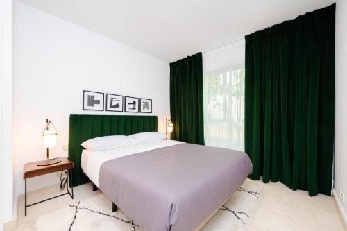 sypialnia z dużym łóżkiem i zielonymi zasłonami w obiekcie Los Castaños Design Apartments in Conde Orgaz w Madrycie