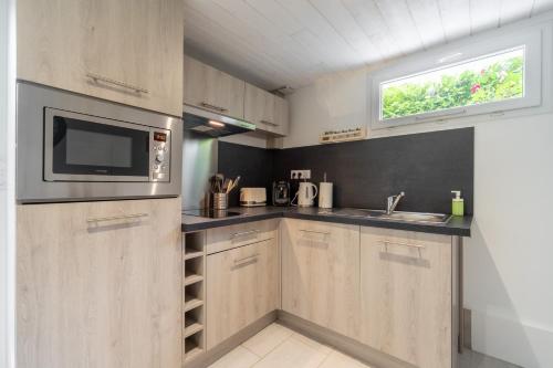 une cuisine avec un micro-ondes et un évier dans l'établissement Résidence confortable au calme quartier St Marceau, à Orléans