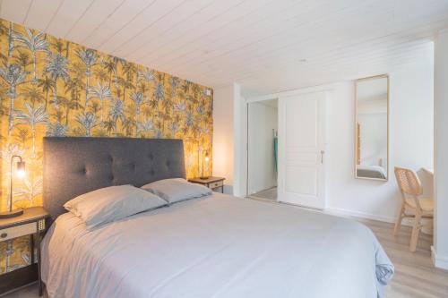 a bedroom with a large bed with a floral wallpaper at Résidence confortable au calme quartier St Marceau in Orléans