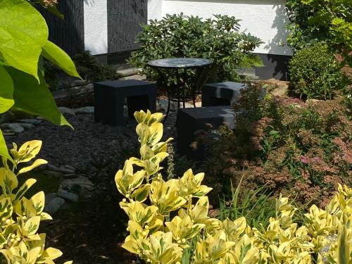 a garden with a table and some yellow flowers at Casa Wimmer in Allendorf an der Lumda