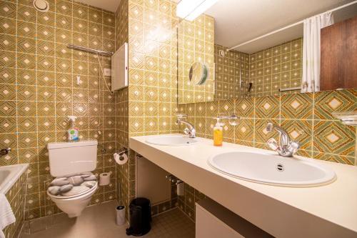 a bathroom with two sinks and a toilet in it at Rothornblick 39 by Arosa Holiday in Arosa
