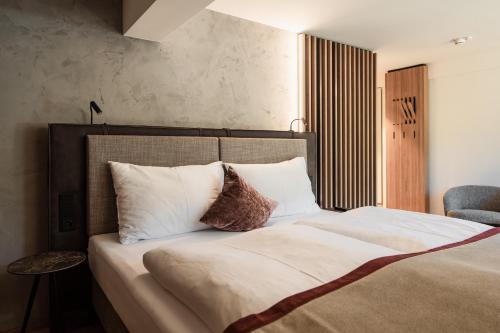 a bedroom with a large bed with white pillows at Hotel Salzburg in Saalbach Hinterglemm