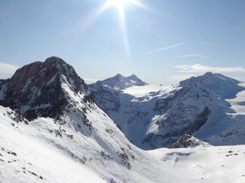 a snow covered mountain with the sun in the sky at Il Rododendro in Ponte di Legno