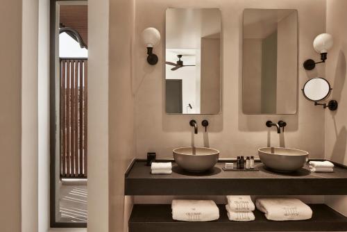 a bathroom with two sinks and a mirror at The Olivar Suites in Mesongi
