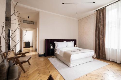 a bedroom with a white bed and a large window at Zola Hotel - Palais de Bohème Adults Only in Vienna