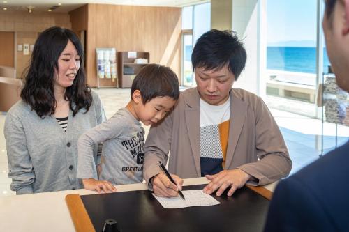 
a man and a woman are looking at a paper at Imagine Hotel & Resort in Hakodate

