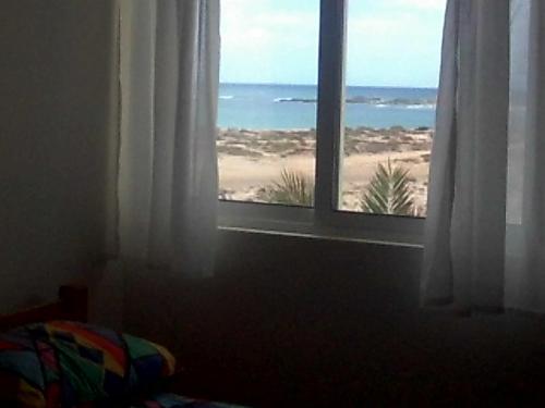 a bedroom with a window with a view of the beach at Vista Oceano - Boa Vista Island in Sal Rei