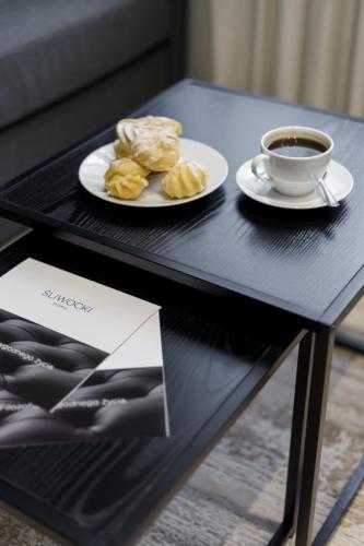 a table with a plate of food and a cup of coffee at Apartamenty L11, Limanowskiego in Poznań