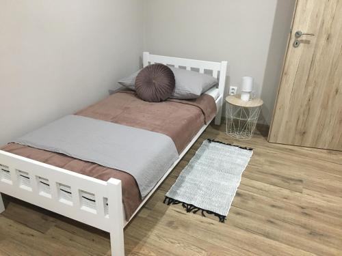 a bedroom with a white bed with a pillow on it at Tokajský domček in Malá Tŕňa