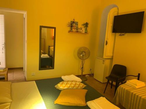 una camera con letto, specchio e ventilatore di Agriostello Riparo ad Anzio