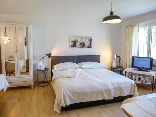 1 dormitorio con 1 cama grande y TV en Apartment Chesa Ova Cotschna 303 by Interhome, en St. Moritz