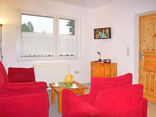 SchwarzにあるHoliday Home Ludwig by Interhomeのリビングルーム(赤い椅子、テーブル付)
