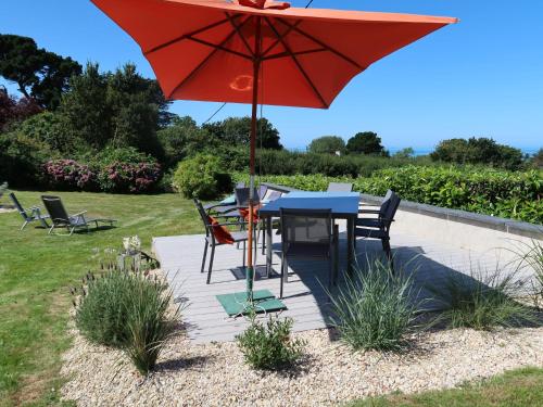 d'une terrasse avec une table et un parasol rouge. dans l'établissement Holiday Home La Rotonde by Interhome, à Port-Blanc