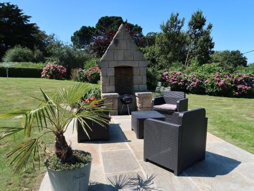 - un jardin avec deux chaises et une cheminée en pierre dans l'établissement Holiday Home La Rotonde by Interhome, à Port-Blanc
