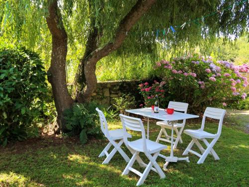 een witte tafel en stoelen onder een boom bij Holiday Home Keranna - LPM102 by Interhome in Lampaul-Ploudalmézeau