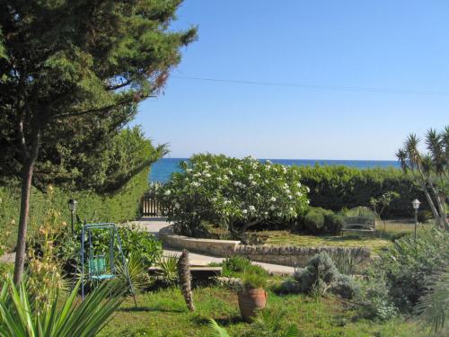 un jardín con un banco y el océano en el fondo en Villa La Punta by Interhome, en Marina di Modica
