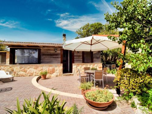 Un patio con una sombrilla y una mesa y sillas. en Villa La Punta by Interhome, en Marina di Modica