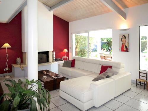 d'un salon avec des meubles blancs et des murs rouges. dans l'établissement Holiday Home Villa Katy by Interhome, à Andernos-les-Bains