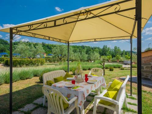 un tavolo e sedie sotto un ombrellone giallo di Apartment Azalea by Interhome a Pian di Scò