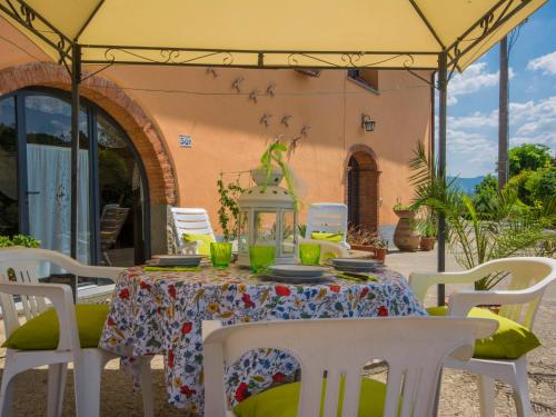 a table with chairs and a green lizard on top at Apartment Edera by Interhome in Pian di Scò