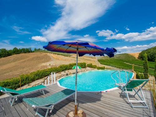 una piscina con due sedie e un ombrellone di Holiday Home Il Vallone by Interhome ad Aia Murata