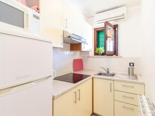 eine Küche mit weißen Geräten und einem Waschbecken in der Unterkunft Apartment Antonella & Napoletano-1 by Interhome in Umag