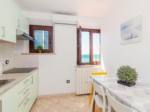 kuchnia i jadalnia ze stołem i krzesłami w obiekcie Apartment Antonella & Napoletano-3 by Interhome w mieście Umag