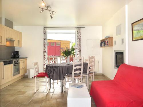 kuchnia i jadalnia ze stołem i czerwoną kanapą w obiekcie Holiday Home La Pailloussette - A w mieście Cancale