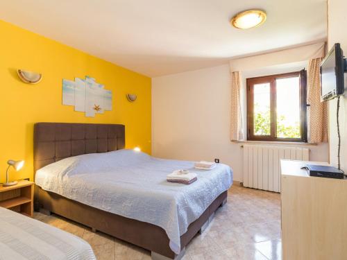 a bedroom with a large bed and a window at Apartment Antonella & Napoletano-3 by Interhome in Umag