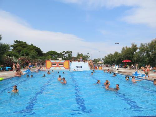 a group of people in a swimming pool at Holiday Home Villaggio San Francesco 5-4 by Interhome in Duna Verde