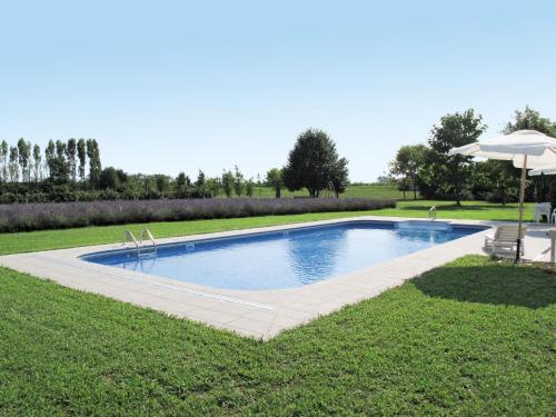 a swimming pool in a yard with an umbrella at Holiday Home Domus Magna-4 by Interhome in Povoletto