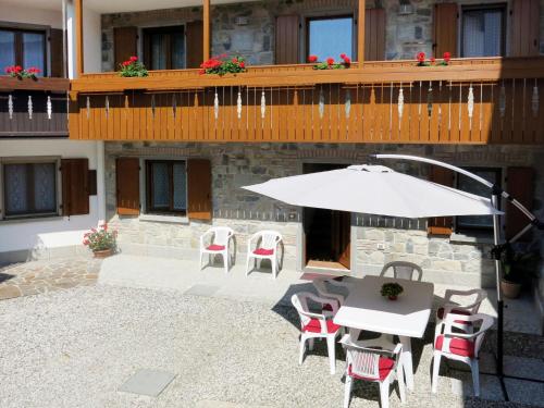 patio con tavolo, sedie e ombrellone di Holiday Home Casa Tranquilla by Interhome a San Leonardo